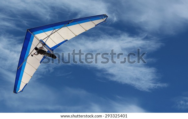 Hang Glider Hang Glider flying in the sky on a bright\
blue day