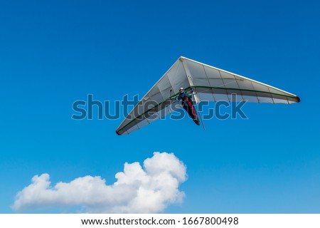 Hang glider wing and blu sky with white cloud. Dream of flying come true.