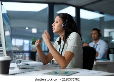 Hang In There, Help Is On The Way. Shot Of A Young Woman Using A Headset And Computer In A Modern Office.