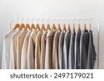 Hanger with beautiful neutral beige, white and gray clothes on a white background.