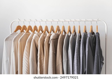 Hanger with beautiful neutral beige, white and gray clothes on a white background. - Powered by Shutterstock