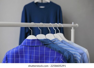 hangers with clothes, wardrobe shirt jacket blue. storing clothes or shopping. stylist selection of look for work and walking. fashion and casual wear - Shutterstock ID 2258605291