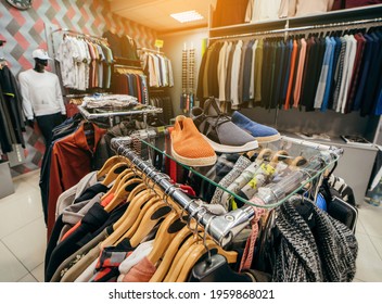 Hangers with different men's clothes in a shop - Shutterstock ID 1959868021