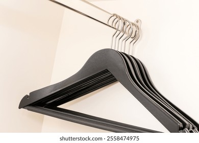 Hangers on a metal rack. Closet organization and wardrobe storage. Minimalist clothing display in a boutique or home.  - Powered by Shutterstock