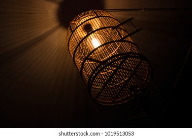 A Hanging Bird Cage With A Light On Inside