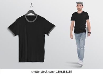 Hanging Black Plan Ringer T Shirt On Wall. Beside A Male Model Walking In Blue Denim Jeans Pant, Holding Laptop In His Hand, Wearing Grey Hat.