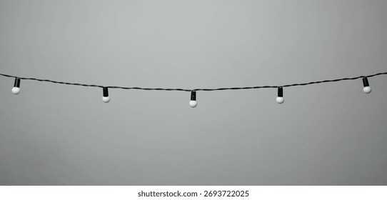 hanging bulb string lights on a grey background 