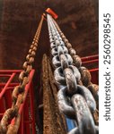 A hanging chain hoist. Chain hoist background. Close-up of hanging chain on chain block lifting.