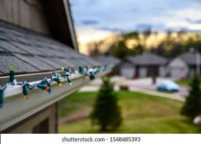 Hanging Christmas lights on gutter with plastic clips - Shutterstock ID 1548485393