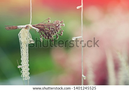 Hanging decoration dry flower, hanging from the wedding arch with green plants and leaves background. Wedding decoration, stylish floristry