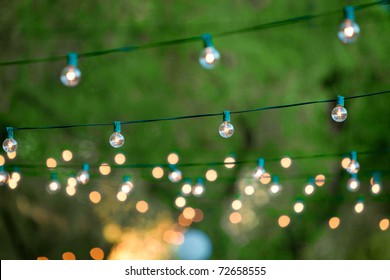 Hanging decorative christmas lights for a back yard party
