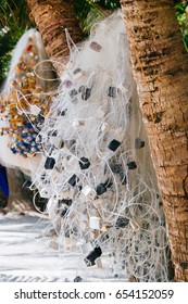 Hanging fishing nets between two palms on the white coral sand beach