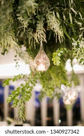 Hanging Installation With Greenery And Glass Ornaments With Tea Light Candles