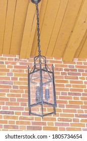 A Hanging Lantern Style Light Fixture Hangs From A Wood Paneled Porch Ceiling