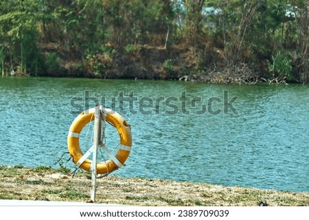 hanging Life Bouy Orange that are ready to be used on the edge of the lake
