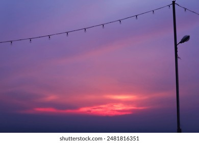 Hanging light bulbs with beautiful dramatic scenic after sunset sky background. A string of hanging lamps and a view of the evening sky. - Powered by Shutterstock