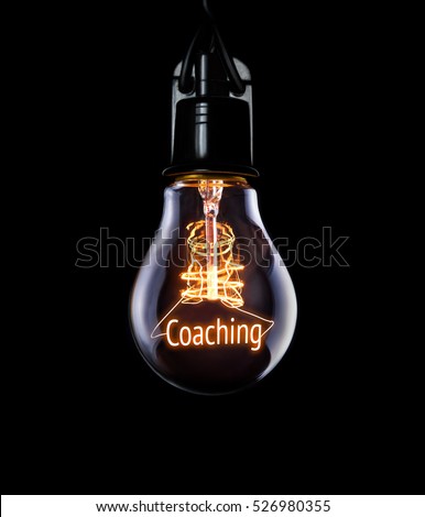 Hanging lightbulb with glowing Coaching concept.