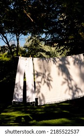 Hanging Out Pants An Linen Clothes In A Clothes Line In The Garden With Plant Shadow On Them And Boho Style