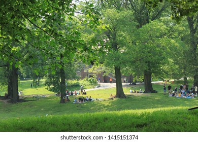 hanging out in prospect park in the late spring sun scores of people are out,  inside prospect park Brooklyn NY some just sun bathing others walking about Park opened in 1867, June 2 2019