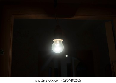 Hanging Single Incandescent Light Bulb In An Old Bathroom