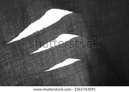 hanging teared rag spread isolated on white background , can use like a background or any texture. hole in the tissue. Unbleached grey fabric with torn stitch, hole and loose threads
