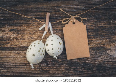 hanging white easter eggs with empty paper note, toned