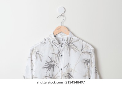 Hanging White Shirt With Wood Hanger On Wall