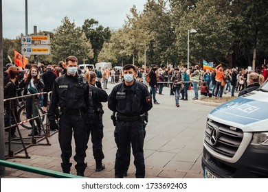 Hannover, Germany, 16.05.2020: The Police Is Observing A Demonstration In The Middle Between Protesters And Counter Protesters During Corona Pandemic Wearing Surgical Face Masks.