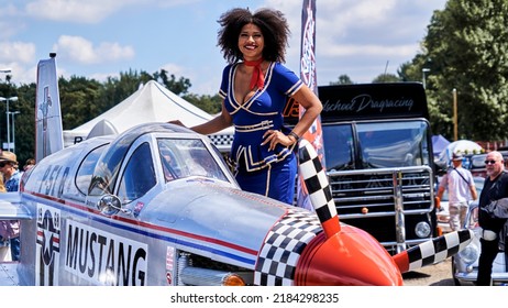 Hannover, Germany, July 23, 2022: Mustang Converted From Ford Sports Car To Airplane With Smiling Pretty Young Black Woman In Blue Uniform