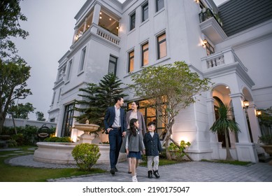 Hanoi City, Vietnam - December 2021: Happy Young Family Consisting Of Parents, Son And Daughter. Family Standing In Front Of Their Luxury Villa. Rich Asian Family.