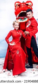 Hanoi City, Vietnam - December 2021: The Couple Wore Red Traditional Vietnamese Costumes, Playfully Posed With A Red Unicorn Head. Lunar Newyear Concept.