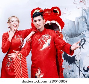 Hanoi City, Vietnam - December 2021: The Couple Wore Red Traditional Vietnamese Costumes, Playfully Posed With A Red Unicorn Head. Lunar Newyear Concept.