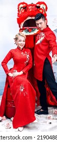 Hanoi City, Vietnam - December 2021: The Couple Wore Red Traditional Vietnamese Costumes, Playfully Posed With A Red Unicorn Head. Lunar Newyear Concept.