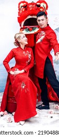 Hanoi City, Vietnam - December 2021: The Couple Wore Red Traditional Vietnamese Costumes, Playfully Posed With A Red Unicorn Head. Lunar Newyear Concept.