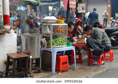 Hanoi, Vietnam - December 13th 2017. Customers Eat At A Street Food Stall In The Historic Old Quarter Of Hanoi
