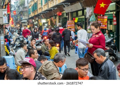 HANOI, VIETNAM   FEBRUARY 15: Waitress takes orders at an outdoor restaurant in the old quarter on February 15, 2015 in Hanoi. The 36 old streets of the old quarter are a major tourist attraction.