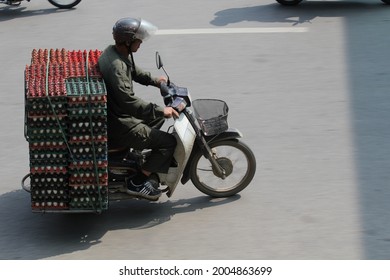 Hanoi, Vietnam - July 26, 2016: A Local Man is riding a scooter and is transporting  many eggs in Tay Son street, Hanoi