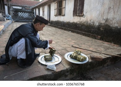 Hanoi, Vietnam - Jun 22, 2017: The man take Chung cake out of cooking pot at So village, Quoc Oai district. Square glutinous rice cake, Vietnamese lunar new year food