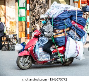 HANOI, VIETNAM, MAY 27, 2018: Vietnamese driving a motorbike and transporting a lot of packages. This is a typical vietnam transport with motorcycle or scooter