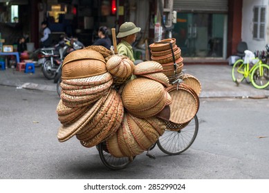 HANOI, VIETNAM - NOV 18, 2013: Unidentified man drives motorcycle with baskets on November 17, 2013 in Hanoi, Vietnam. Street vending by bike is an essential part of life in Vietnam.