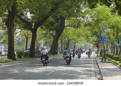 HANOI, VIETNAM - OCT 11, 2014: Vehicles traveling on a green street of Hanoi capital. Hanoi is known as the 'City for Peace'.