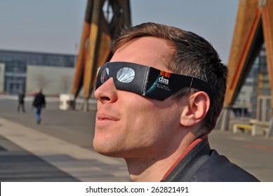 HANOVER, GERMANY, 13 MARCH 2015 - A Visitor Of CeBit Is Watching The Solar Eclipse Through A Special Pair Of Glasses.