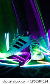 Hanover - Lower Saxony, Germany - 05.2021- Shot Of White Adidas Superstar Sneakers In The Neon Lights. Image With Selective Focus