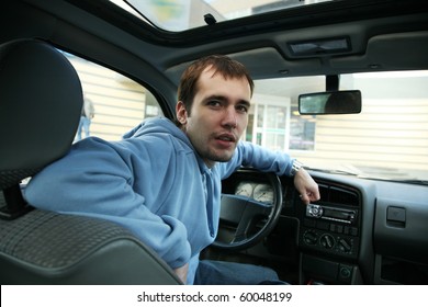 Hansdome Young Adult Man In Car In Drivers Seat, Looking Back At Camera.