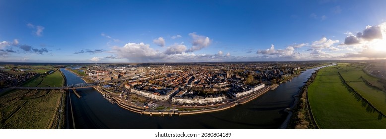 Hanseatic medieval city seen from across the river IJssel passing the white countenance facades on the boulevard. Aerial cityscape of tower town Zutphen. - Shutterstock ID 2080804189