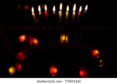 Hanukkah candles ,Hanukkah Jewish holiday , with black background and color lights.
Lighting the eighth candle of Hanukkah