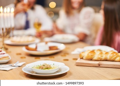 Hanukkah Dinner. Family Gathered Around The Table With Traditional Dishes