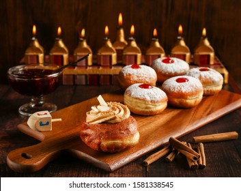 Hanukkah donuts with straberry jam on wooden brown background. Happy hanukkah. 