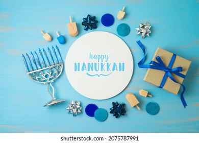 Hanukkah Holiday Concept With Menorah, Gift Box And Spinning Top On Blue Background. Top View From Above