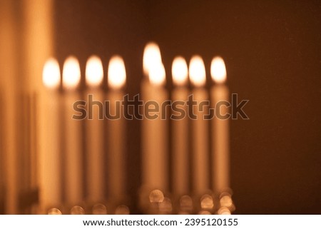 Hanukkah menorah, or hanukkiah with burning candles is out of focus. Jewish holiday Hanukkah background. Hanukkah lamp, nine-branched candelabrum is out of focus. Blurred background. Stock fotó © 